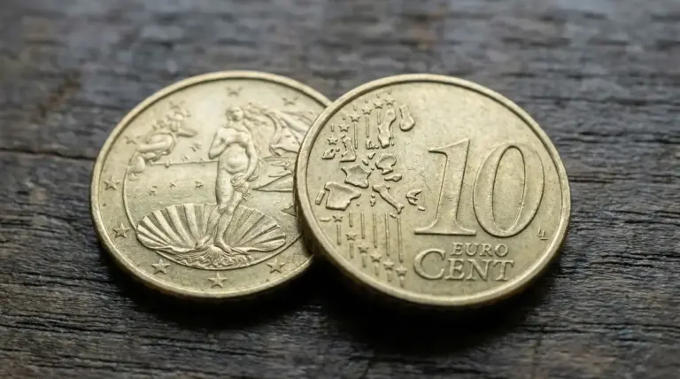 Due monete da 10 centesimi di euro su una superficie in legno